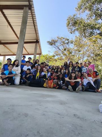 Foto coletiva dos participantes em uma área coberta e aberta durante o acampamento de instruções.