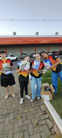 Participantes do clube com livros durante uma ação de distribuição gratuita.